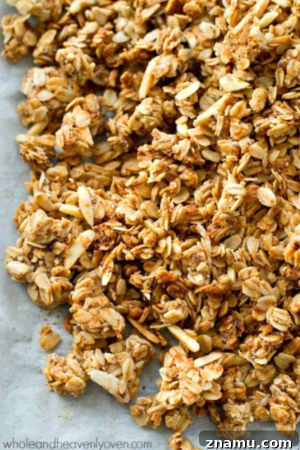 Close-up of golden-brown almond butter chai spice granola clusters cooling on a baking sheet, showcasing its perfect crunch and texture