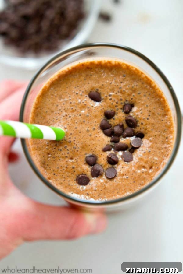 Rise and Shine Mocha Smoothie 7 A glass of Cafe Mocha Breakfast Smoothie with a straw, placed on a cozy setting.