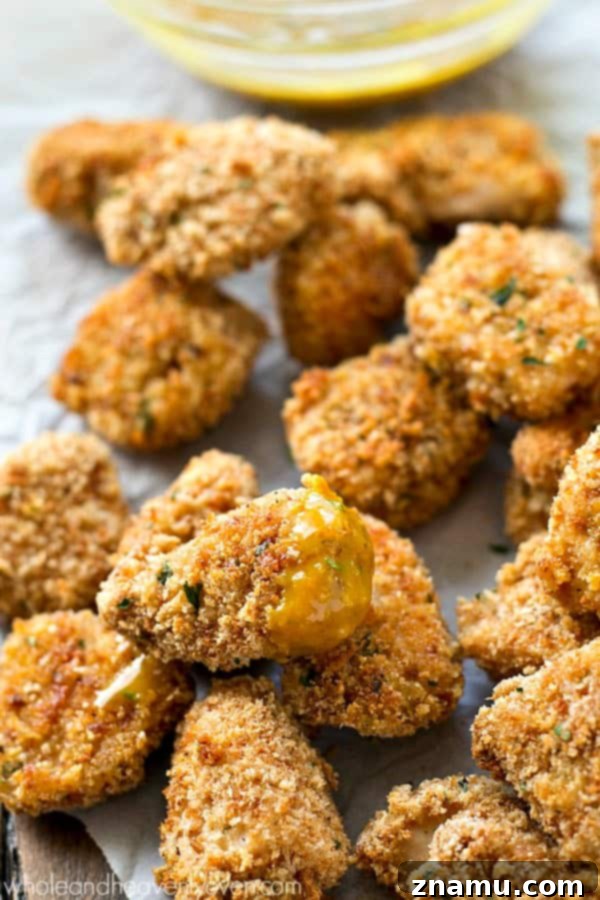 Golden Crunch Baked Chicken Bites with Zesty Honey Mustard 2 Extra-crispy oven-baked chicken nuggets served with a tangy honey mustard dip, perfect for Super Bowl or any party.