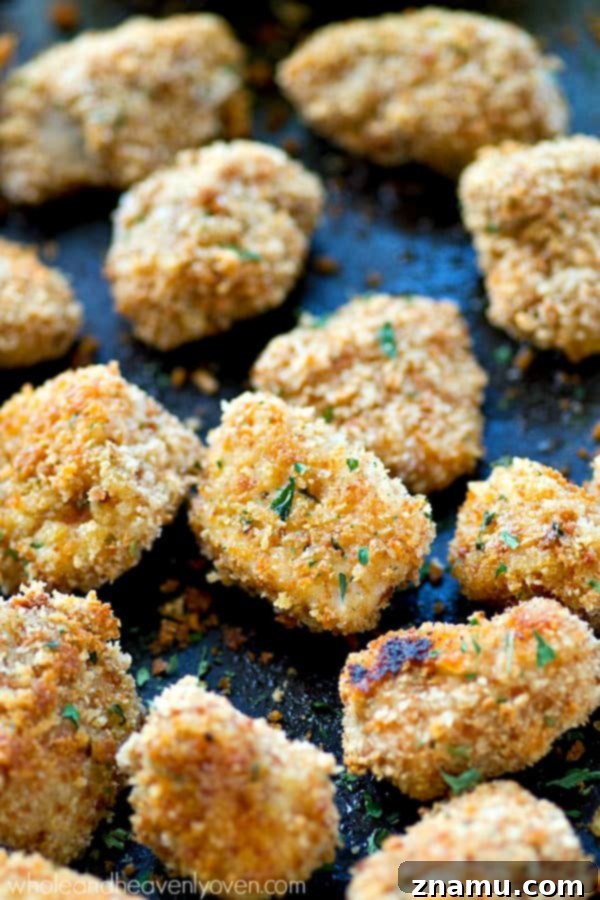 Golden Crunch Baked Chicken Bites with Zesty Honey Mustard 6 A baking sheet filled with golden brown, extra-crispy oven-baked chicken nuggets, fresh out of the oven.
