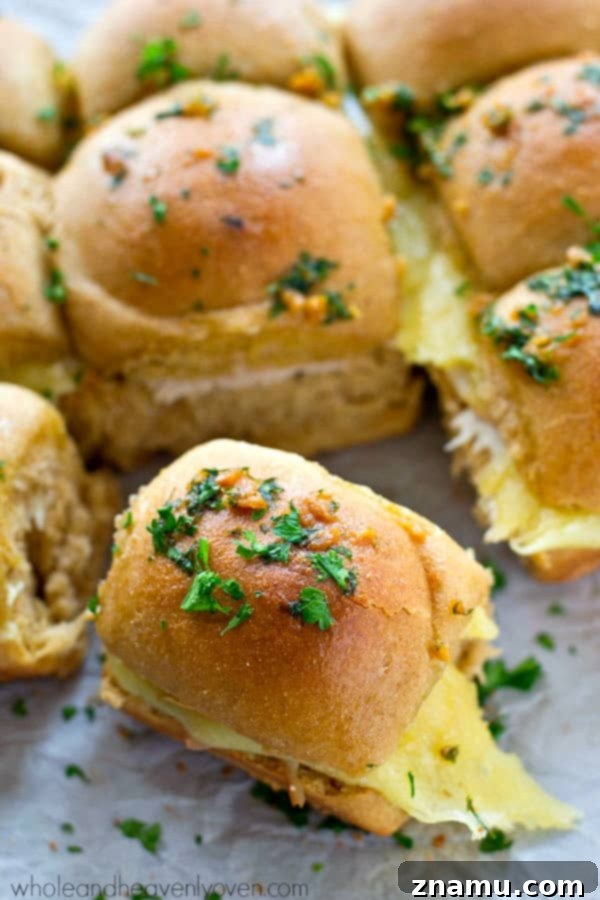 Ultimate Garlic Butter Monte Cristo Pull-Apart Sliders 3 Close-up of golden brown Monte Cristo Sliders with melted cheese oozing out, fresh from the oven.