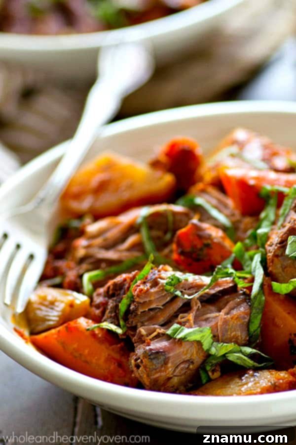 Cooked Italian pot roast with root vegetables and fresh basil, ready to be served.