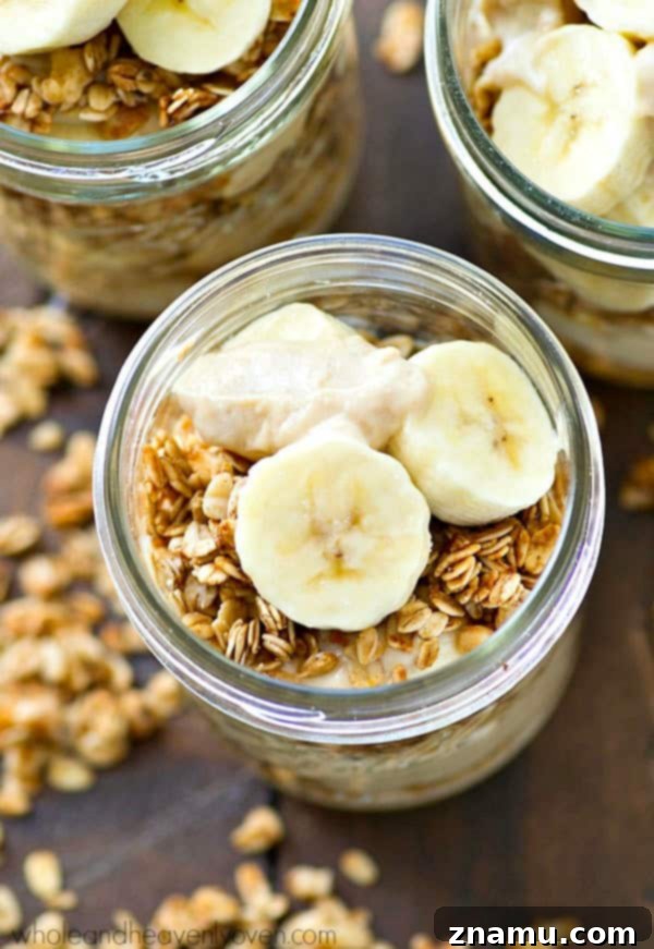 Banana Cream Pie Parfaits with Granola Crunch 2 Delicious and healthy banana cream pie granola parfaits served in clear glasses, topped with fresh banana slices and a sprinkle of mini chocolate chips.
