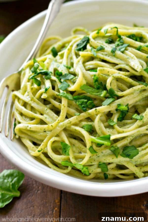 Guilt-Free Creamy Spinach Fettuccine Alfredo 4 A bowl of Lighter Creamy Spinach Fettuccine Alfredo on a rustic table, showing the pasta generously coated in the green sauce.