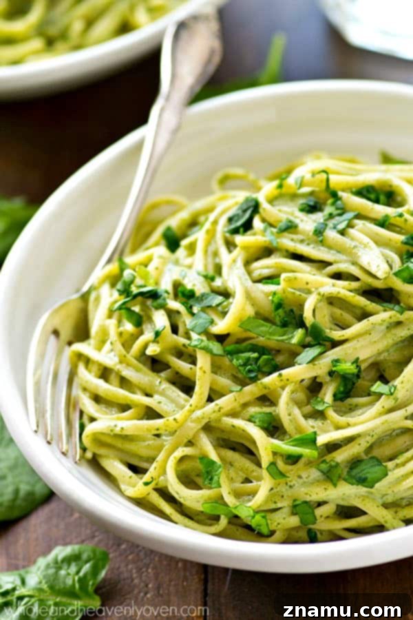 Guilt-Free Creamy Spinach Fettuccine Alfredo 6 A serving of Lighter Creamy Spinach Fettuccine Alfredo garnished with fresh parsley and grated Parmesan cheese, ready to eat.