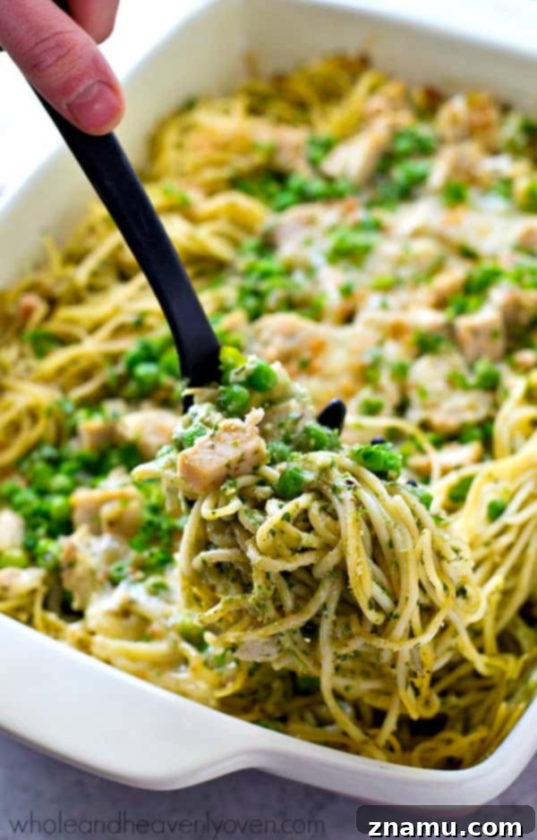 Close-up of creamy chicken pesto tetrazzini in a baking dish, highlighting the pasta, chicken, and rich sauce