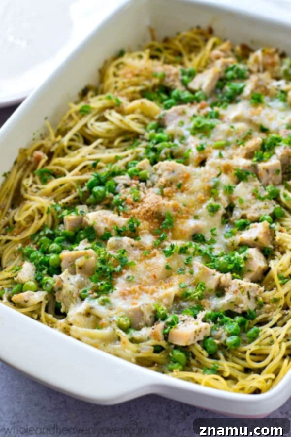 Scoop of Basil Pesto Chicken Tetrazzini being served, showing the layers of pasta, chicken, and creamy pesto sauce