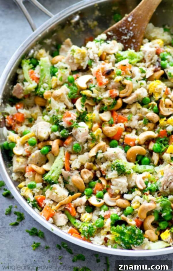 Rainbow Chicken Cauliflower Fried Rice 2 Delicious Chicken Rainbow Veggie Cauliflower Fried Rice served in a bowl, featuring vibrant colors of vegetables and chicken.
