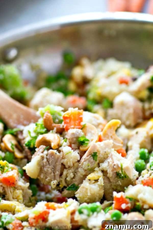 Rainbow Chicken Cauliflower Fried Rice 5 Close-up of Chicken Rainbow Veggie Cauliflower Fried Rice in a pan, ready to be served, showing the golden texture of cauliflower rice.