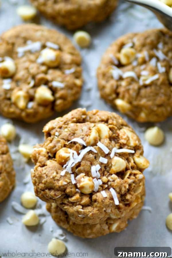 Chewy White Chocolate Coconut Oat Bliss 2 The best chewy white chocolate coconut oatmeal cookies piled high on a plate, ready to be enjoyed.