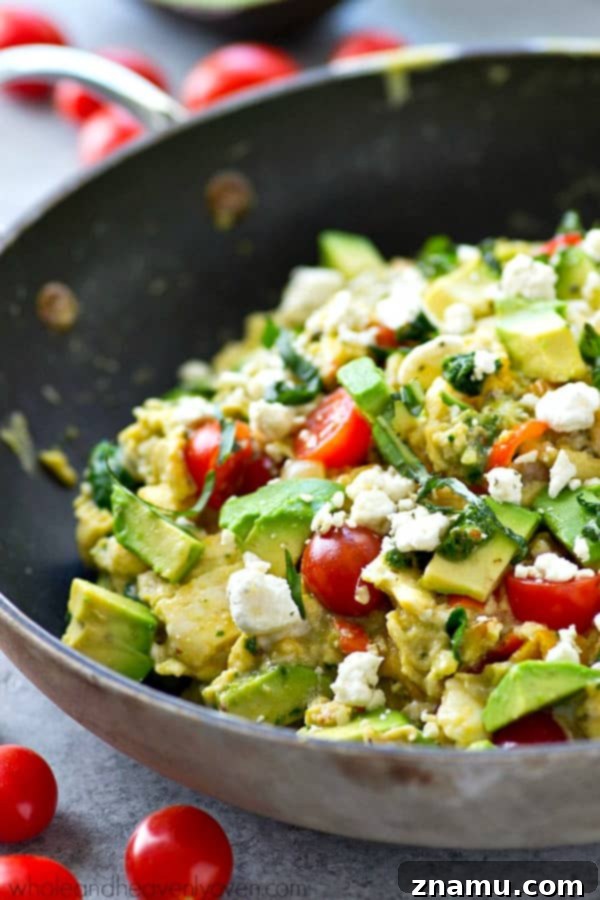 Pesto Garden Scramble 6 A bowl of Garden Veggie Pesto Scrambled Eggs with avocado slices and fresh basil, ready for a healthy breakfast