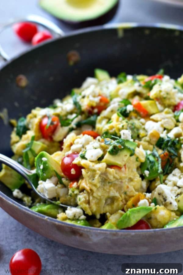Pesto Garden Scramble 7 A large serving of Garden Veggie Pesto Scrambled Eggs garnished with fresh herbs in a ceramic bowl