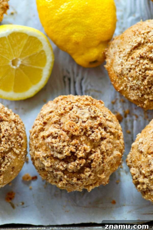 Light Lemon Streusel Greek Yogurt Muffins 7 A close-up of a single lemon crumb muffin, showing its golden color, generous streusel, and soft texture, ready to be eaten.
