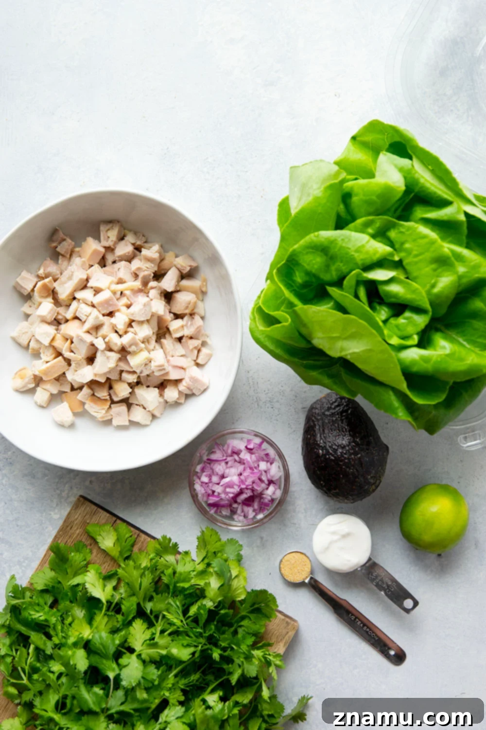 Avocado Chicken Lettuce Wraps 4 A beautifully arranged plate of avocado chicken salad lettuce wraps, garnished with fresh lime wedges and cilantro.