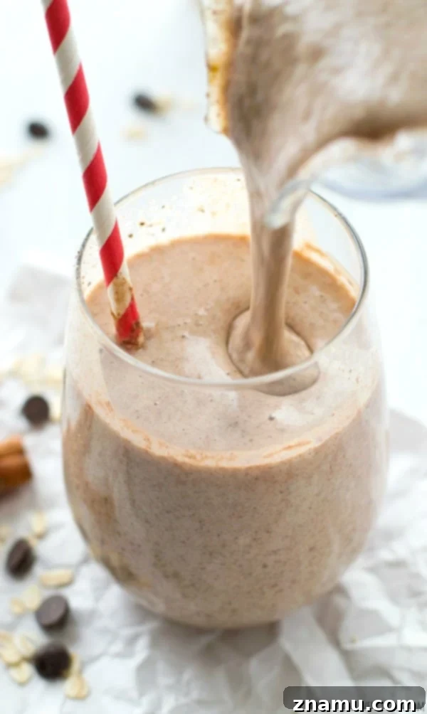 Chai Spiced Banana Overnight Oats 11 Creamy Cinnamon Roll Chocolate Chip Oatmeal Smoothie in a glass, topped with a sprinkle of cinnamon.