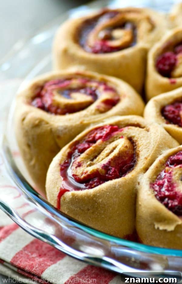 Zesty Orange Raspberry Swirl Buns 6 Sliced Orange Raspberry Swirl Cinnamon Rolls arranged beautifully, showcasing the vibrant filling.