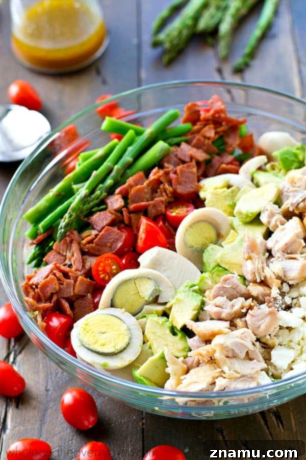 Bright Asparagus Cobb Salad with a Tangy Red Wine Vinaigrette 3 Close-up of a beautifully layered Springtime Asparagus Cobb Salad showcasing fresh asparagus, chicken, and eggs