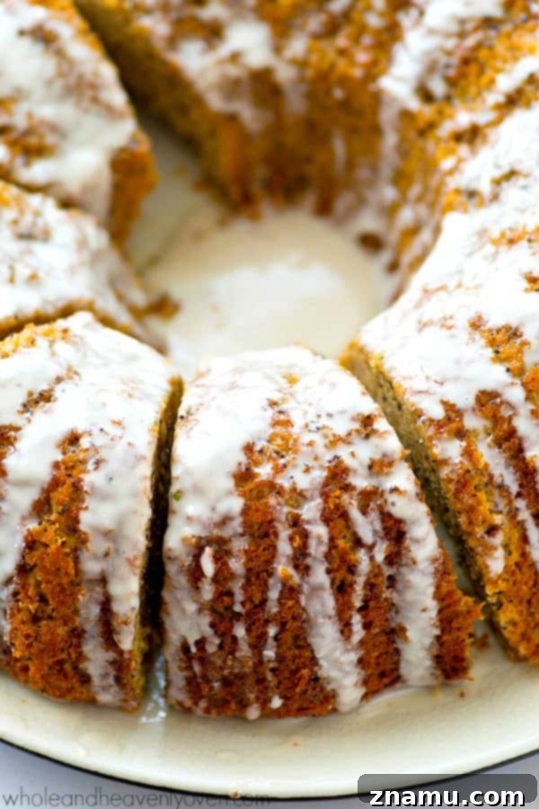 Airy Lemon Poppyseed Bundt Delight 3 Close-up shot of a slice of lemon poppyseed bundt cake revealing its moist, tender crumb and abundant poppyseeds, with a glossy lemon glaze drizzled over the top.