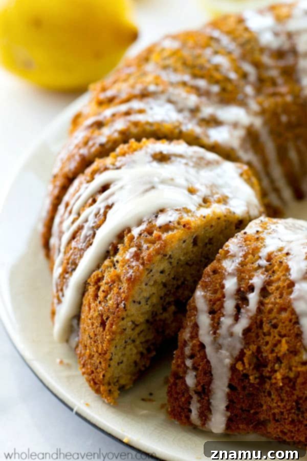 Airy Lemon Poppyseed Bundt Delight 5 A perfectly baked bundt cake, showcasing its elegant fluted design, with a thin, glossy lemon glaze cascading down its sides, indicating its moist texture.