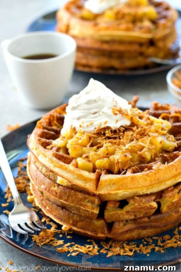 Tropical Overnight Waffle Bliss 4 A stack of overnight yeast waffles with a bowl of warm pina colada topping and fresh ingredients in the background.