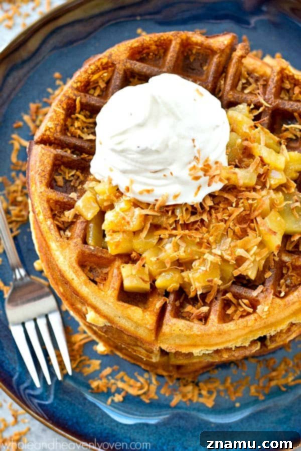 Tropical Overnight Waffle Bliss 5 A close-up of a single crispy yeast waffle on a white plate, showcasing its texture.
