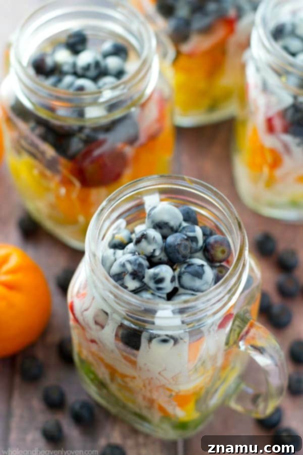 Vibrant Fruit Medley with Zesty Ginger-Lime Drizzle 10 Rainbow fruit salad layered in a glass jar, featuring vibrant fruits and a creamy citrus yogurt dressing, ideal for summer picnics.