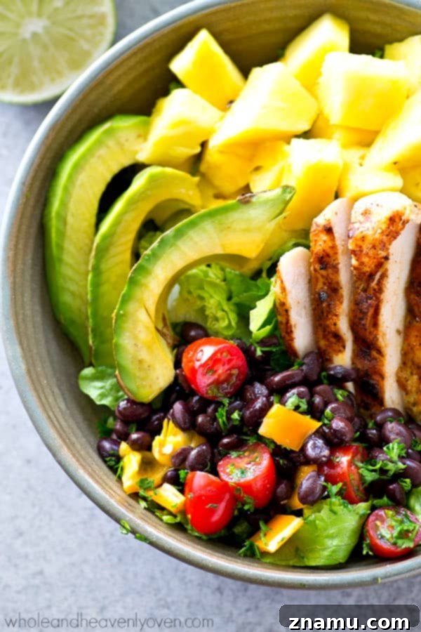 Vibrant Tropical Grilled Chicken Mexican Salad Bowls 3 Close-up shot of a richly packed Tropical Grilled Chicken Mexican Salad Bowl showcasing colorful ingredients like grilled chicken, pineapple, avocado, and fresh vegetables.