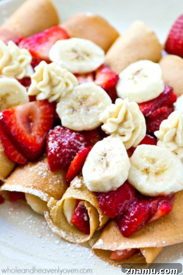 Delicious Strawberry Banana Cheesecake Crepes, enchilada-style, served beautifully on a white platter for a memorable brunch.