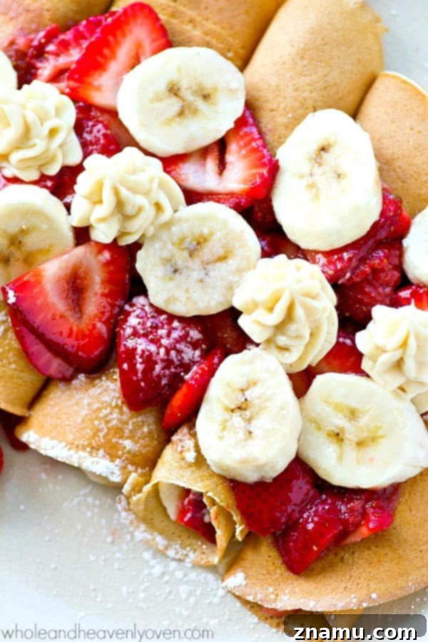 An inviting overhead shot of a full serving platter of Strawberry Banana Cheesecake Crepes, ideal for a festive brunch or celebratory occasion.