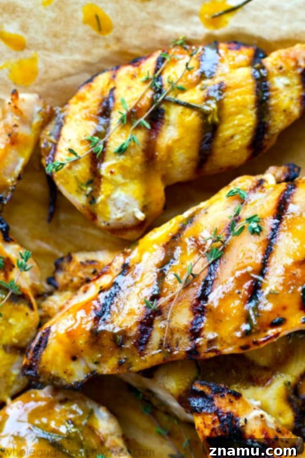 Sweet & Tangy Honey Mustard Grilled Chicken Cutlets 5 Grilled chicken cutlets being brushed with honey mustard sauce.