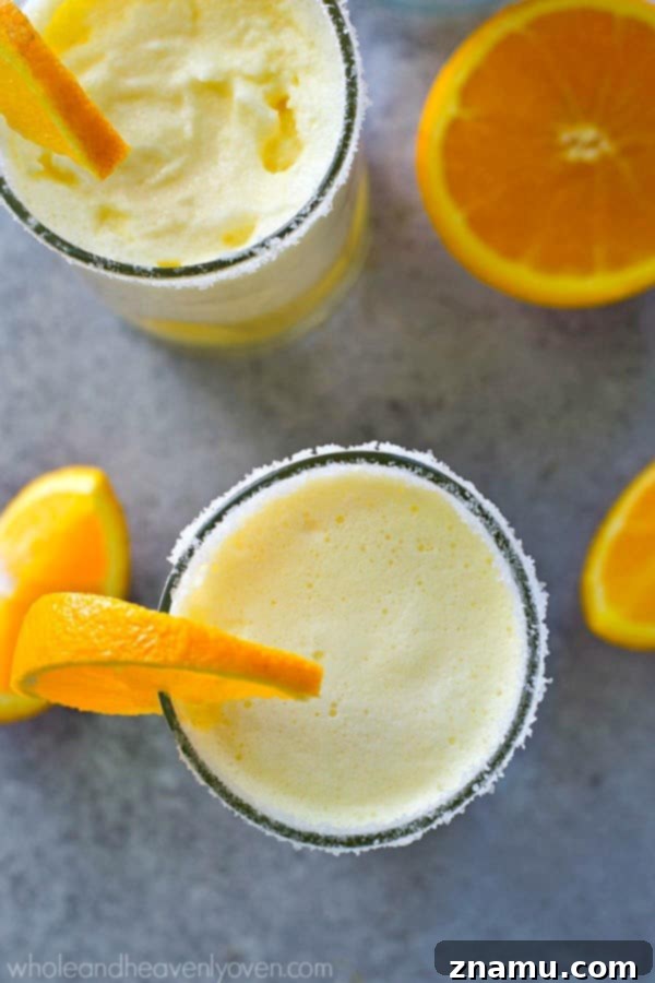 Close-up of a frosty orange creamsicle cocktail slushie, highlighting its creamy texture.