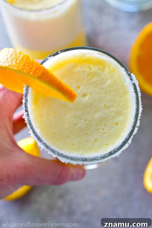 Enjoying a refreshing Orange Creamsicle Cocktail Slushie, perfect for summer.