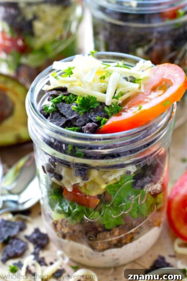Kavanozda Kat Kat Taco Salatası, Chipotle Ranch Soslu 4 Hands holding a glass jar with vibrant layers of taco salad ingredients
