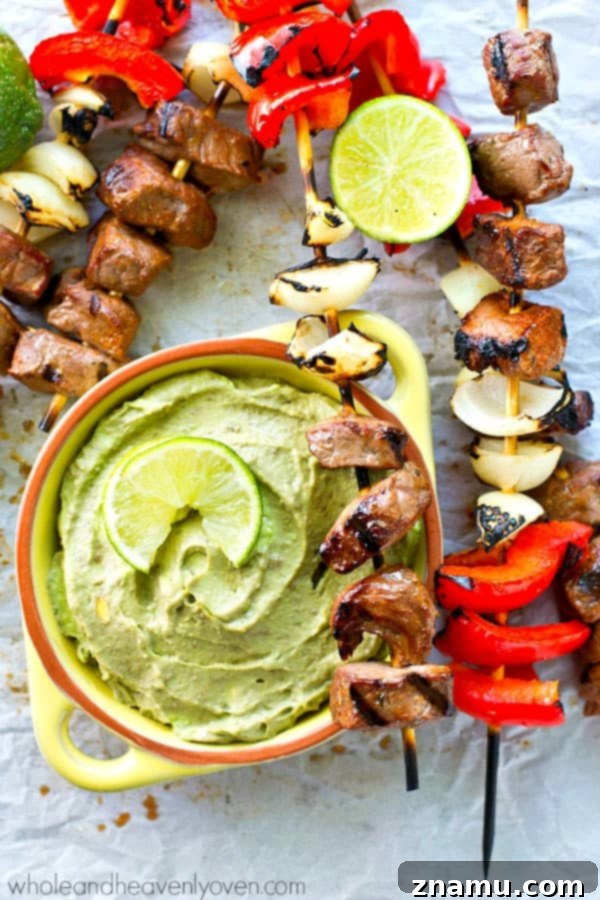 Delicious grilled steak and pepper kebabs served with a creamy avocado dip, perfect for summer entertaining.
