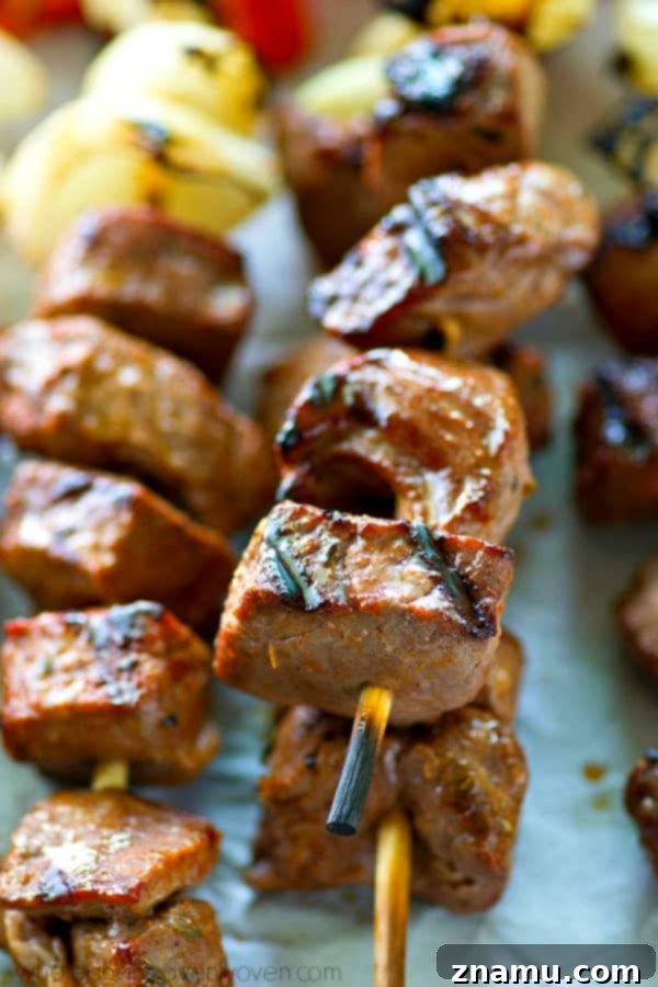 Prepared steak and pepper kebabs on skewers, ready for grilling.