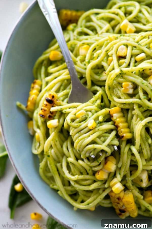 Creamy Avocado Pesto Spaghetti with Smoky Grilled Corn 7 A bowl overflowing with avocado pesto spaghetti and grilled corn, ready to be enjoyed.