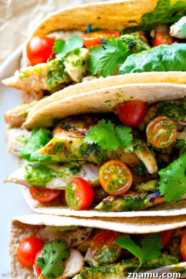 Chargrilled Greek Chicken Tacos with Fresh Herb Chimichurri 3 Close-up of a grilled chicken taco with fresh toppings and chimichurri sauce, highlighting its delicious summer flavors.