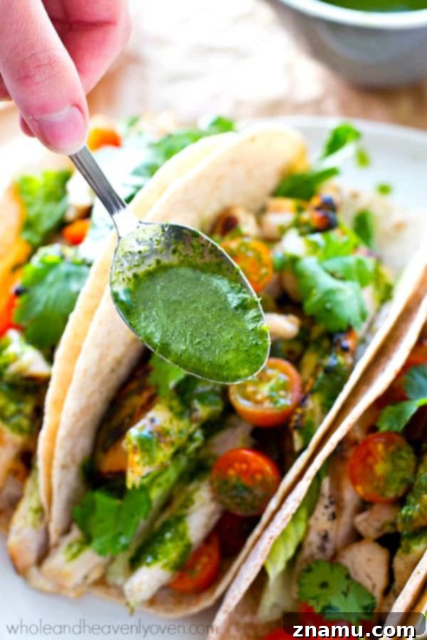 Chargrilled Greek Chicken Tacos with Fresh Herb Chimichurri 7 Fully assembled grilled chicken tacos with chimichurri sauce and fresh ingredients, ready to eat.