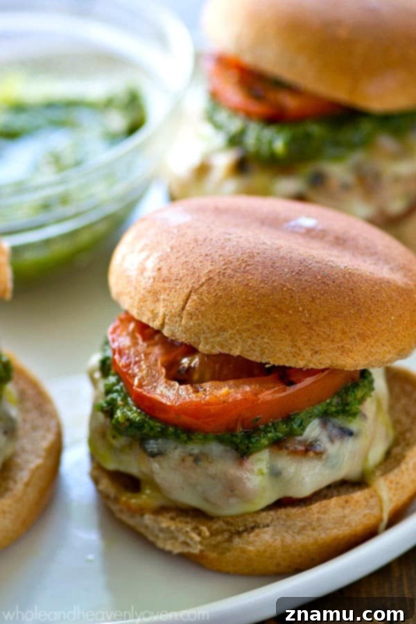 Grilled Pesto Turkey Burgers with Melted Mozzarella and Smoky Tomatoes 2 Delicious Pesto Mozzarella Turkey Burger with fresh basil and grilled tomatoes on a bun