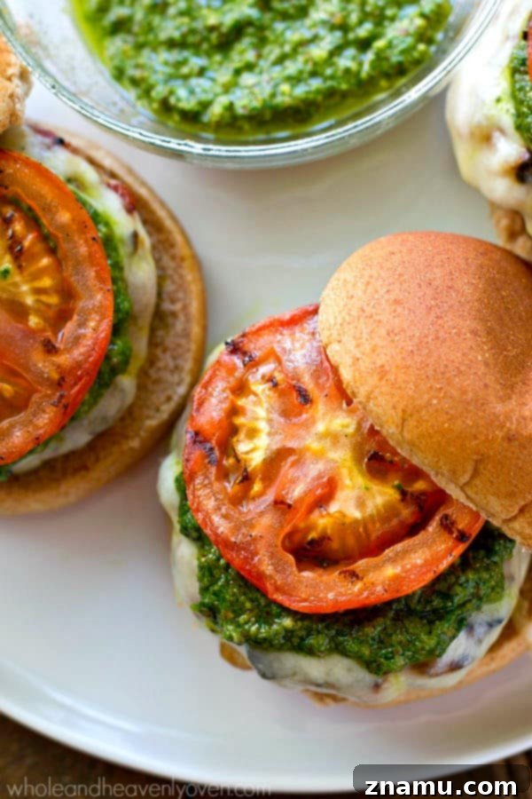 Grilled Pesto Turkey Burgers with Melted Mozzarella and Smoky Tomatoes 6 A completed Pesto Mozzarella Turkey Burger on a bun with grilled tomatoes and basil