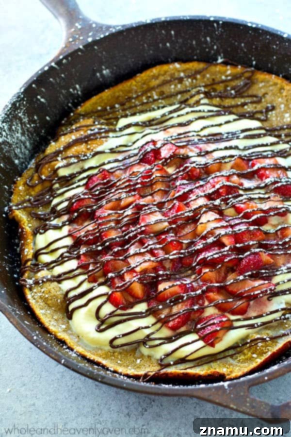Strawberry Shortcake Oven Puff 5 A warm, fluffy Dutch Baby pancake in a cast iron skillet, topped with a generous swirl of freshly whipped cream, ready for berries.