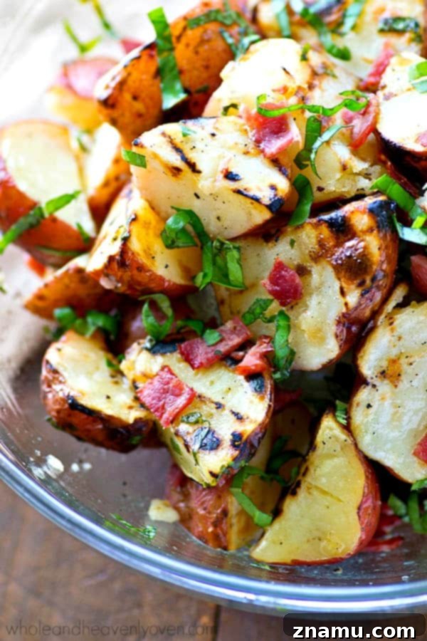 Grill-Kissed Red Potato Salad with Bacon-Basil Vinaigrette 3 Close-up of smoky grilled red potatoes with crisp bacon bits and fresh basil vinaigrette, showcasing the vibrant colors and textures of this lighter summer potato salad alternative.