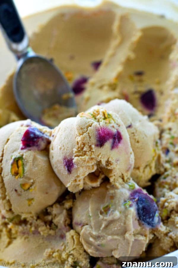 Creamy Vanilla Ice Cream with Cherries and Pistachios Close-up shot of creamy homemade vanilla ice cream base with vibrant roasted cherries and green pistachios.