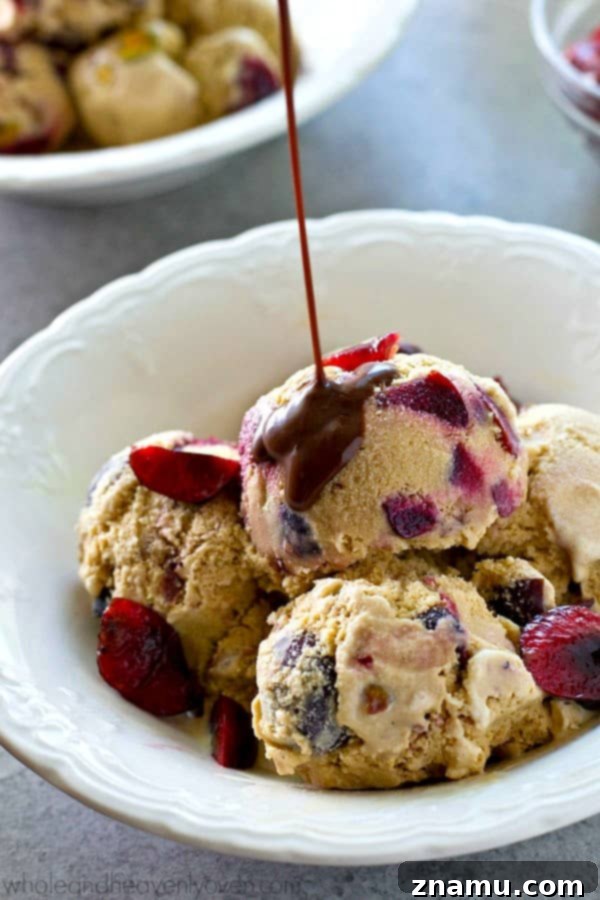Scoop of Ice Cream with Hot Fudge A beautifully scooped portion of roasted cherry pistachio ice cream with a generous hot fudge topping.