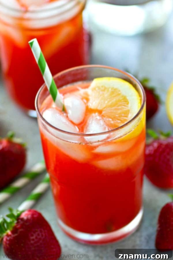 Strawberry Sunset Lemonade Cocktail 5 Glasses filled with the Pink Strawberry Lemonade Cocktail, garnished with fresh fruit