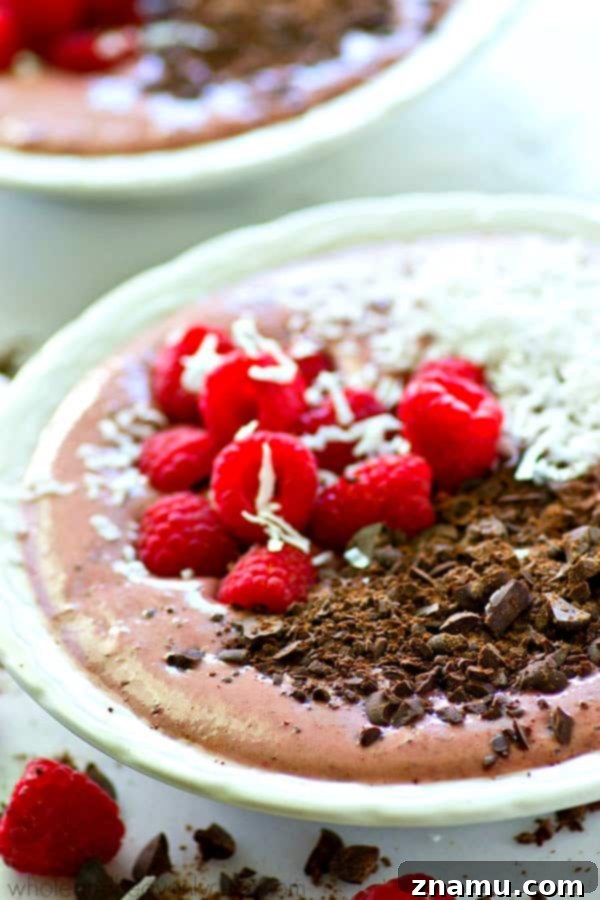 Overhead view of a beautifully garnished raspberry dark chocolate smoothie bowl