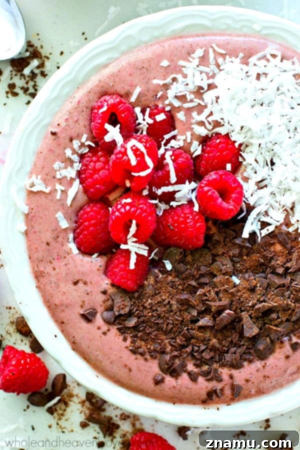 Rich Raspberry Dark Chocolate Smoothie Bowls 7 Close-up of a spoon digging into a thick and creamy raspberry dark chocolate smoothie bowl