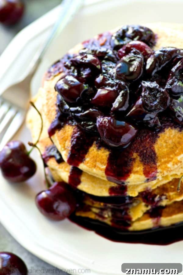 A close-up of the homemade fresh cherry compote simmering in a saucepan, showing the rich color and syrupy texture.