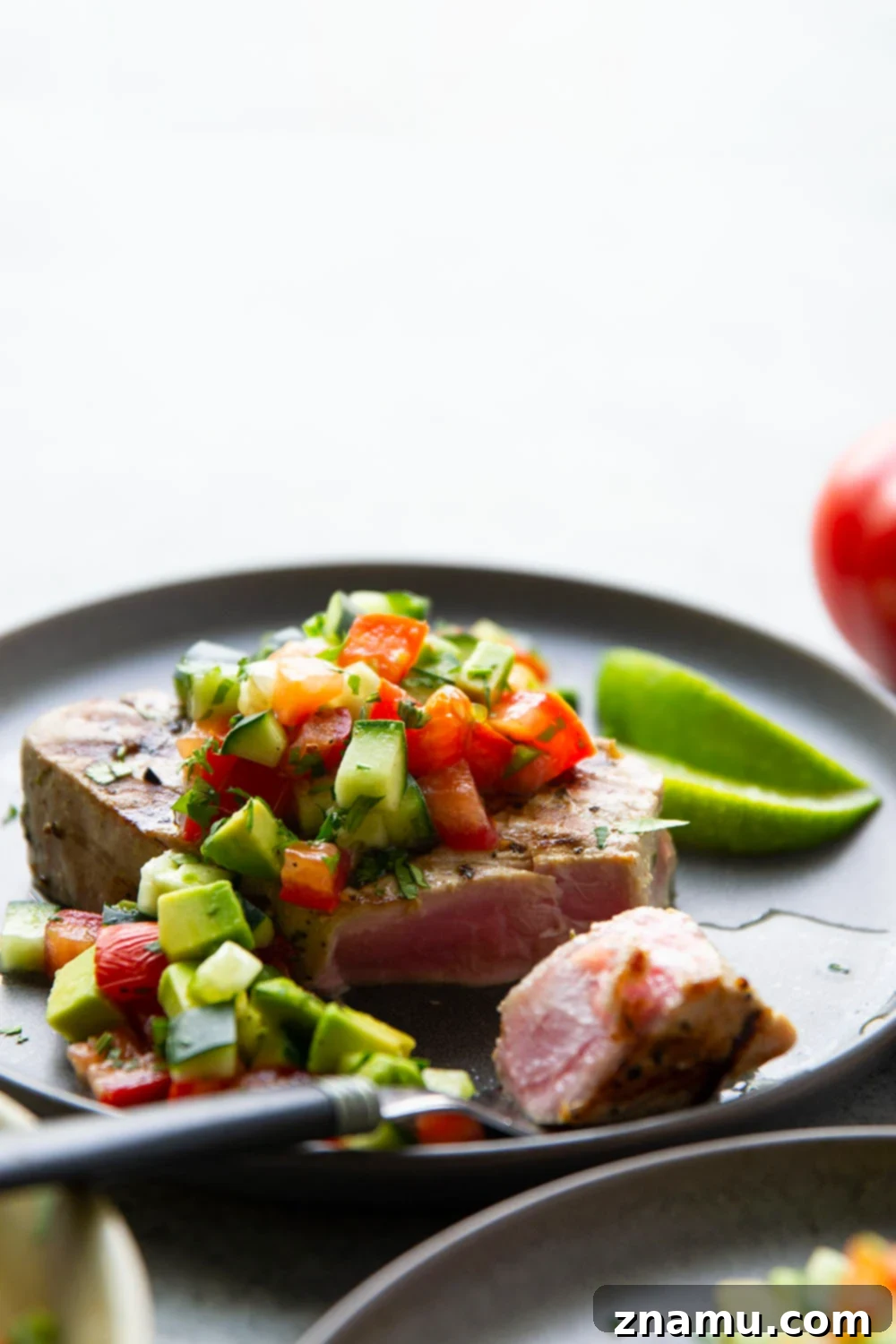 Cilantro-Lime Grilled Tuna with Avocado Cucumber Salsa 5 Fresh ahi tuna steaks on a cutting board, ready for grilling.