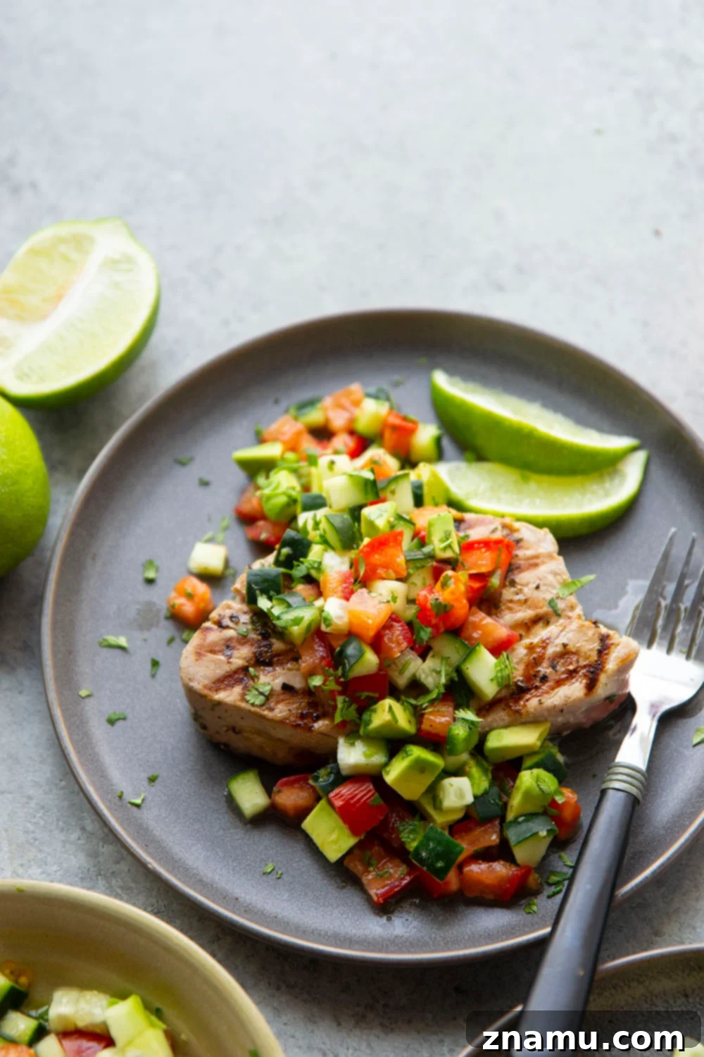 Cilantro-Lime Grilled Tuna with Avocado Cucumber Salsa 6 Plated Cilantro Lime Grilled Tuna with a large spoonful of avocado cucumber salsa, ready to be served.
